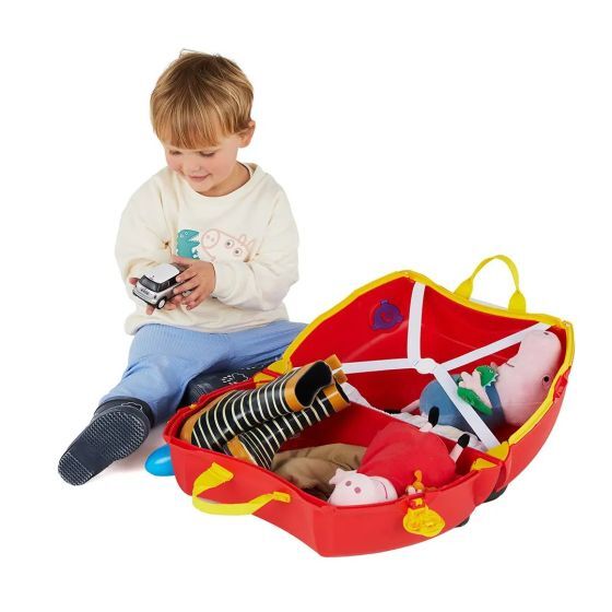 Dieťa si balí hračky do kufríka Trunki